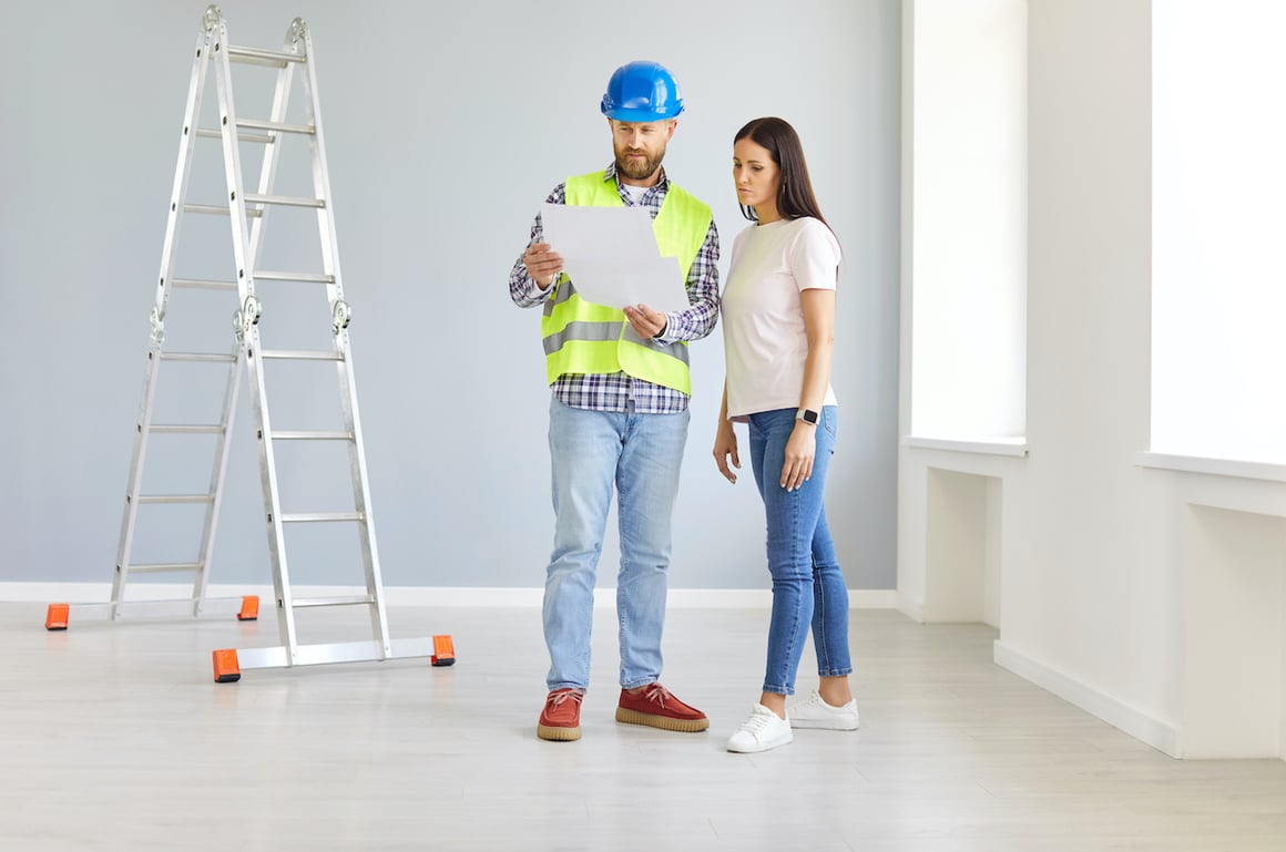 flooring-contractor-speaking-with-homeowner-next-to-ladder