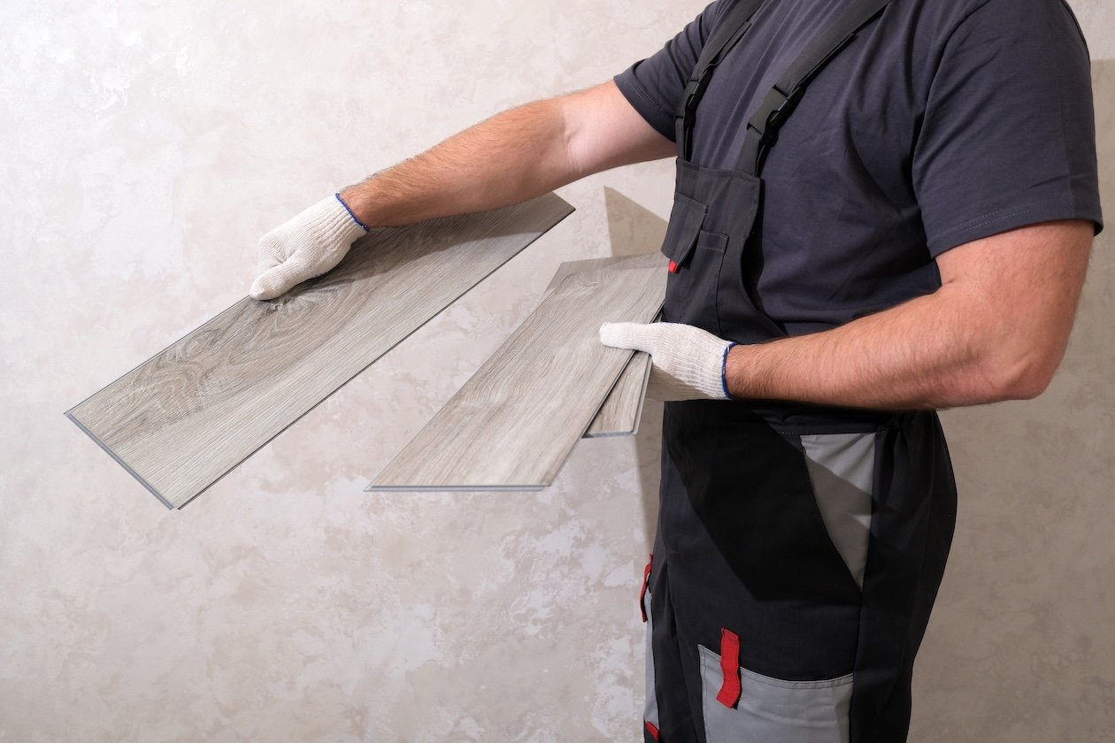 contractor installing vinyl plank flooring during home renovation project