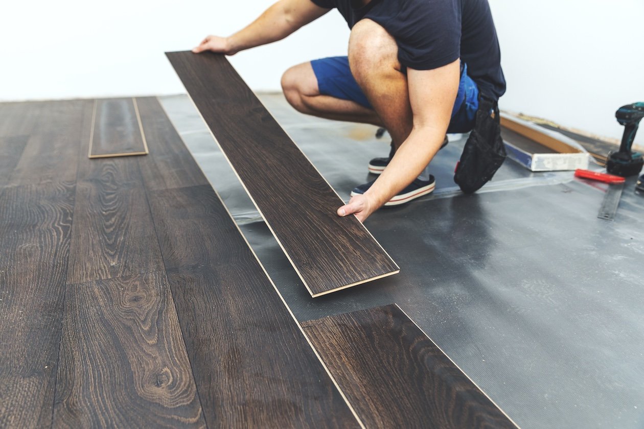 Man installing dark wood floor planks