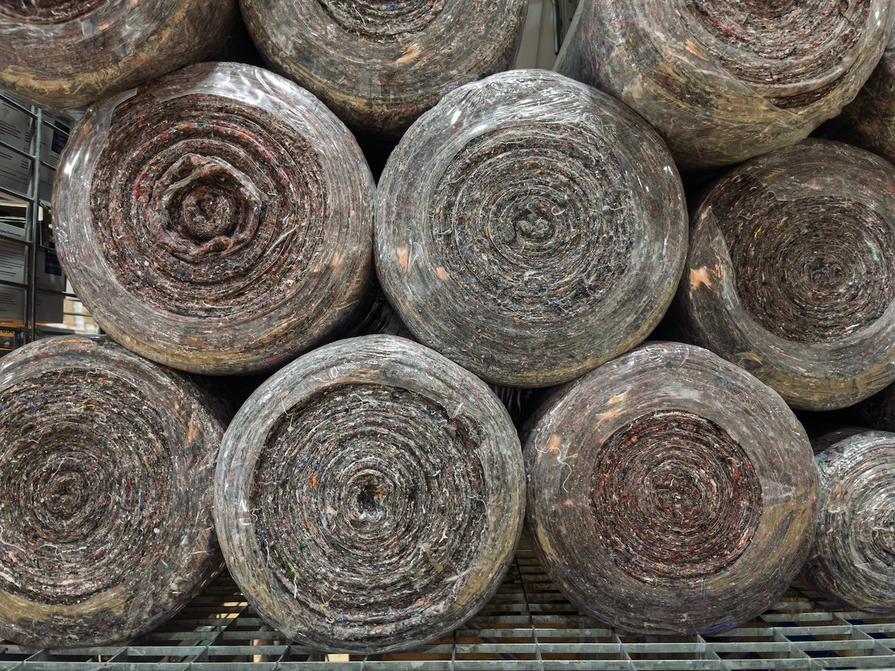 Flooring materials and carpet rolls organized in warehouse inventory for digital tracking and purchase order automation.