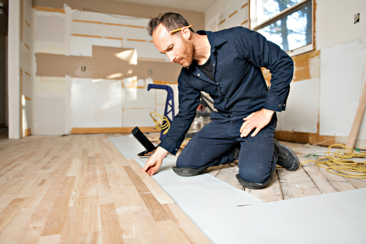 Professional flooring installer working on a kitchen remodel.