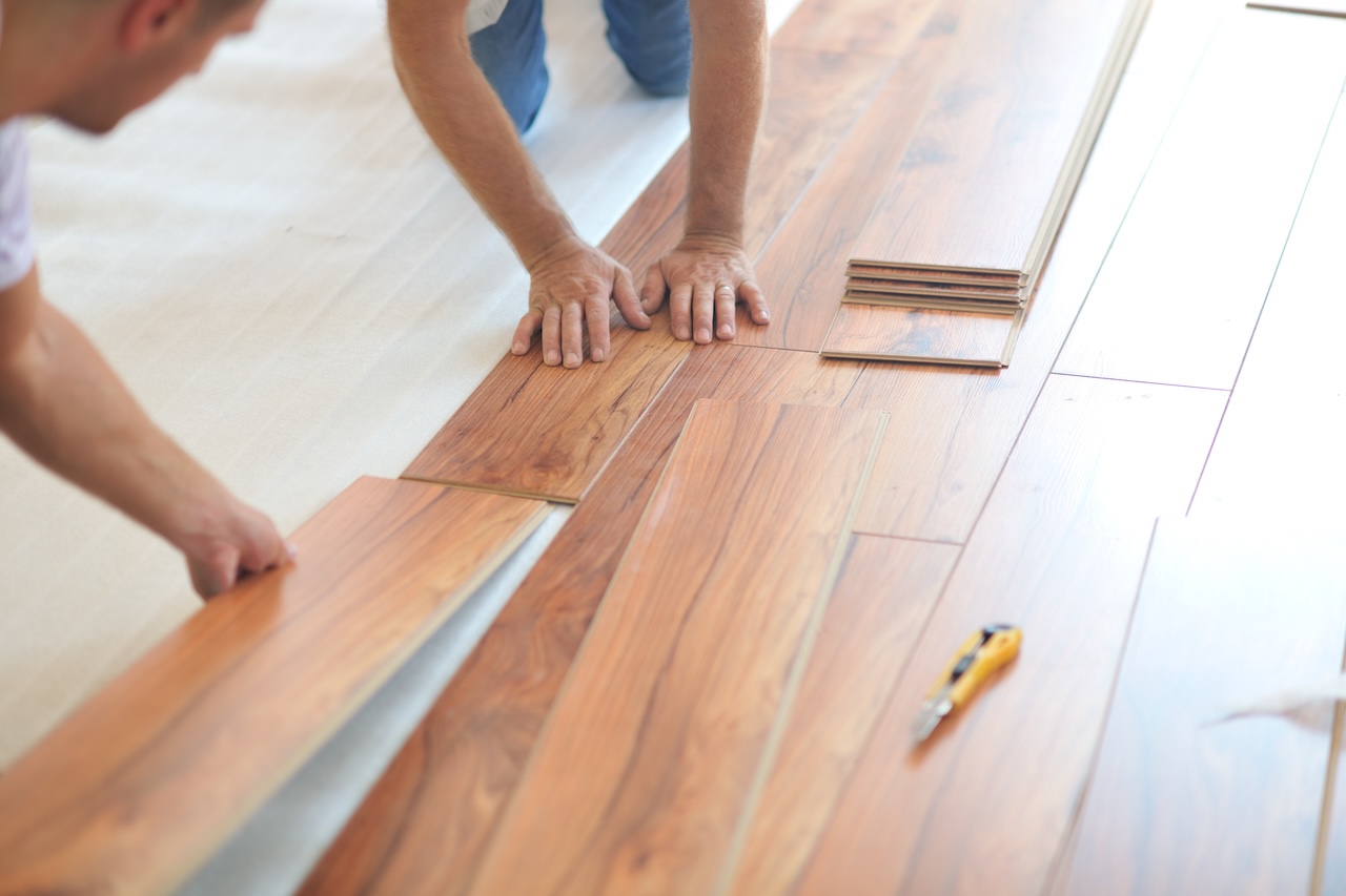 Flooring professionals installing laminate flooring