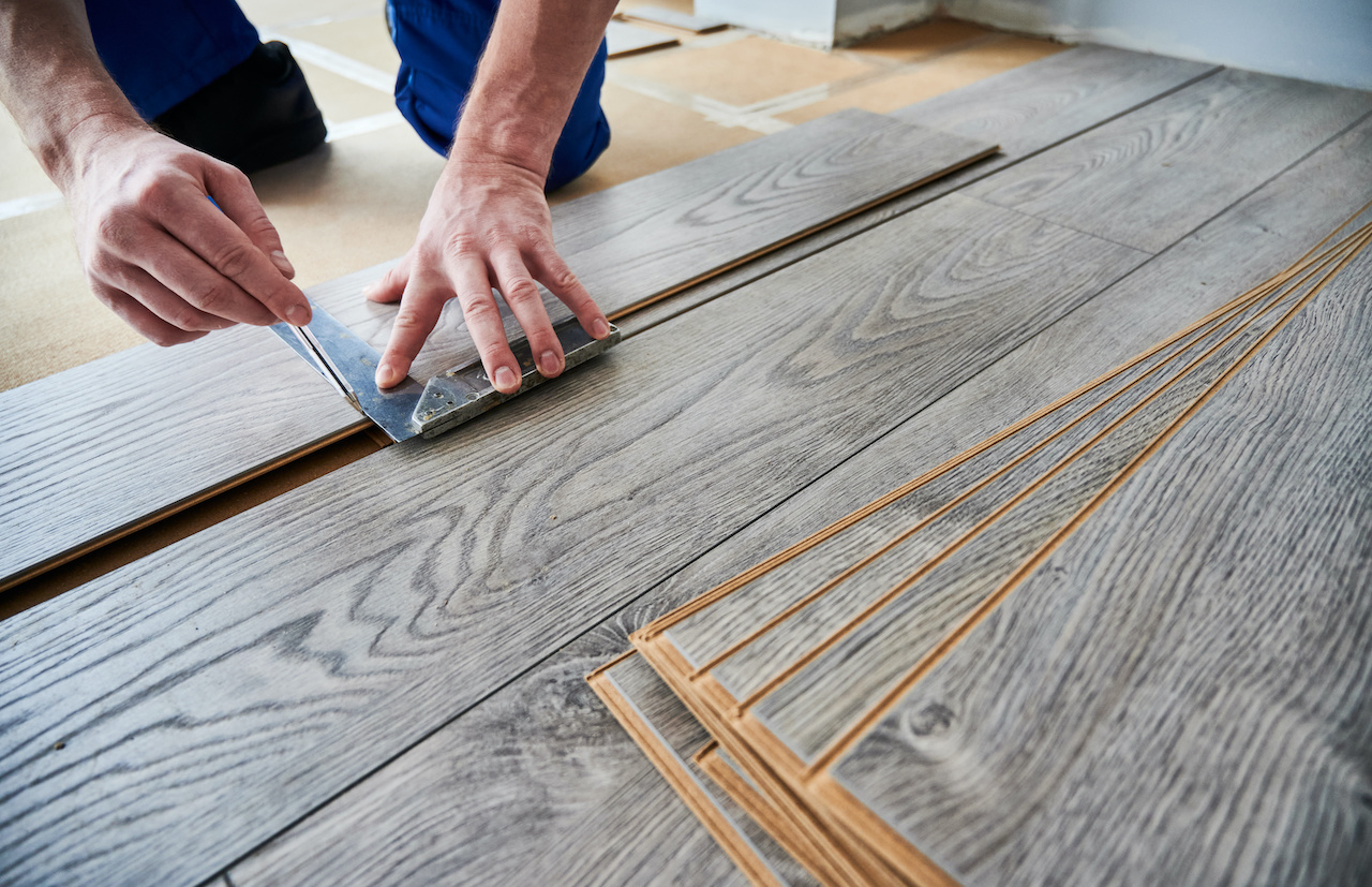 Flooring professional measuring new floor.