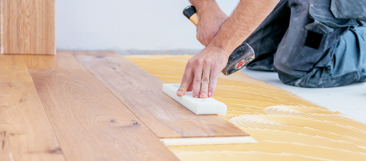 Installing light hardwood flooring.