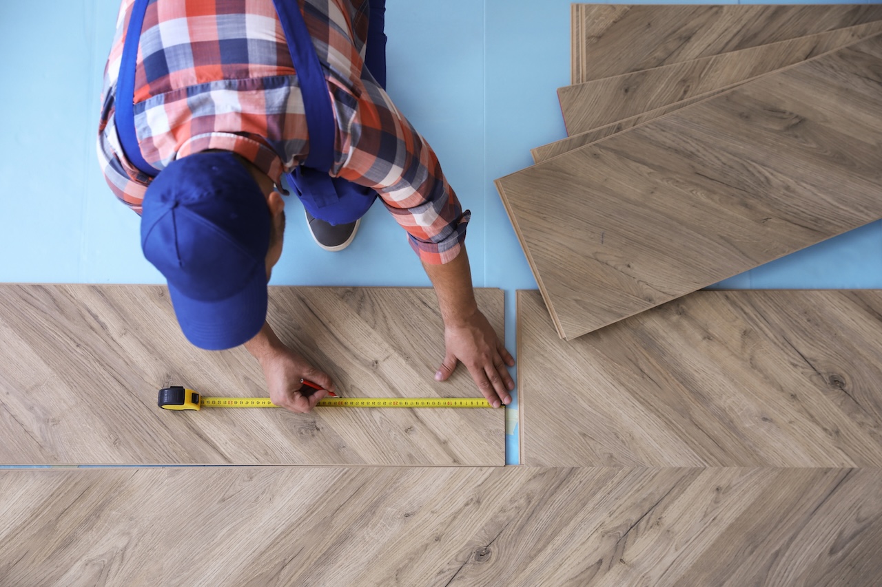 View above a worker installing laminate flooring.