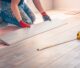 Worker professionally installs floor boards