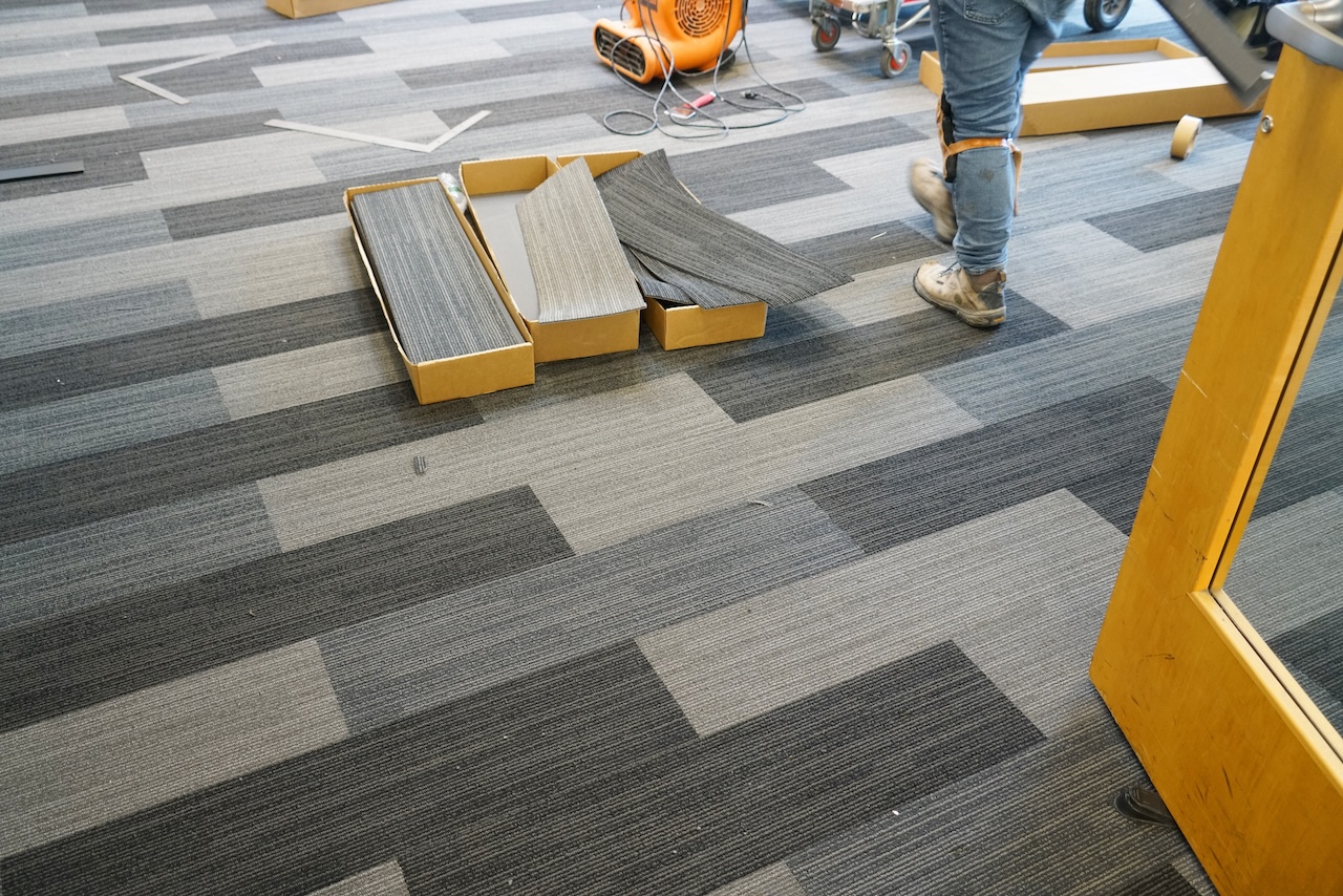 Commercial office space with newly installed gray carpet flooring, showing clean and professional finish.