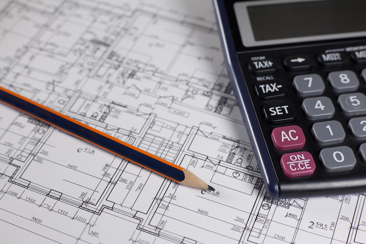 Pencil and calculator resting on a house floor plan.